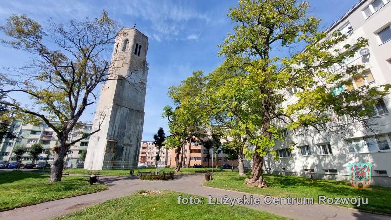 gotycka wieża dawnego kościoła stojąca wśród dwudziestowiecznych bloków,